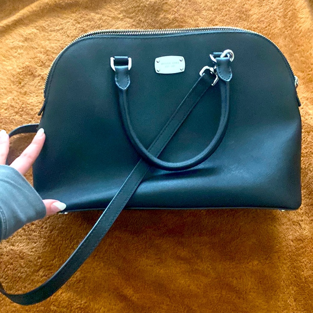 Black and silver Michael Kors hand bag with shoulder strap.